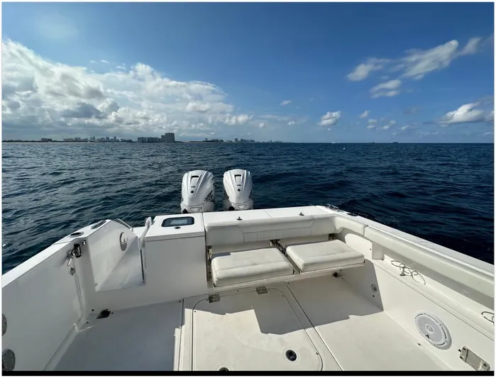 Yacht Photos Pics 2019 Everglades 340 DC boat on open sea with city skyline in background.