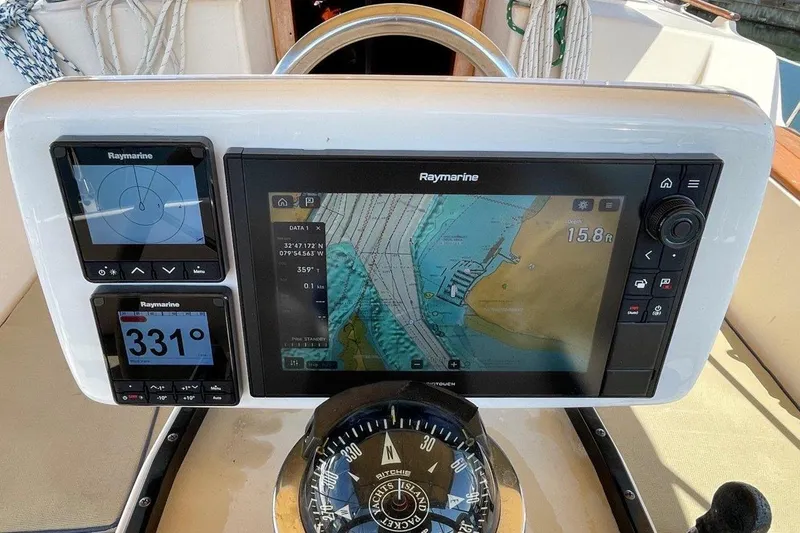 Dream Flower Yacht Photos Pics Navigation system on 1995 Island Packet 40 sailboat, featuring Raymarine displays and a compass.
