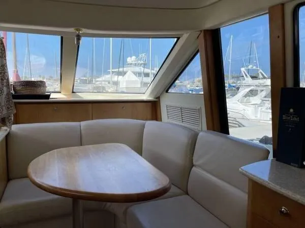  Yacht Photos Pics Interior of 2000 Silverton 453 Motor Yacht with white seating and wooden table.