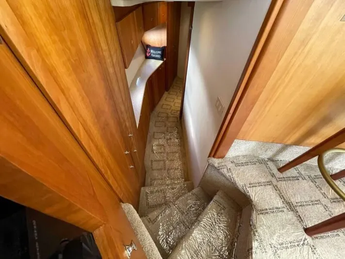  Yacht Photos Pics Interior staircase of 2000 Silverton 453 Motor Yacht with wooden paneling and carpeted steps.