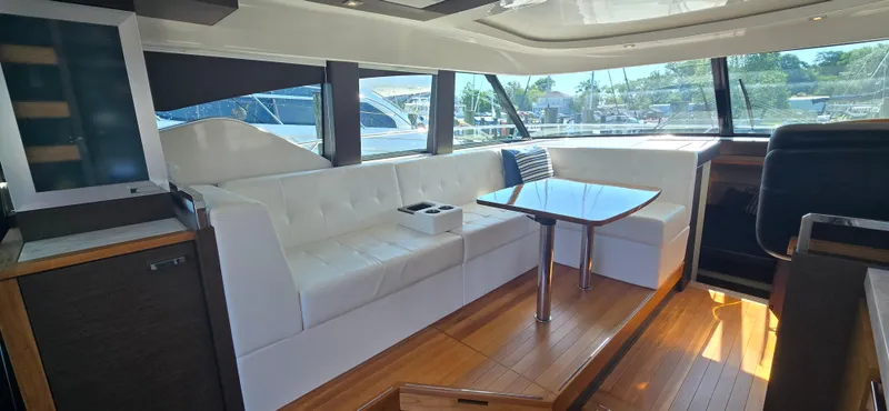 Andros Yacht Photos Pics Luxurious interior of 2016 Tiara Yachts C44 Coupe with white seating and wooden flooring.