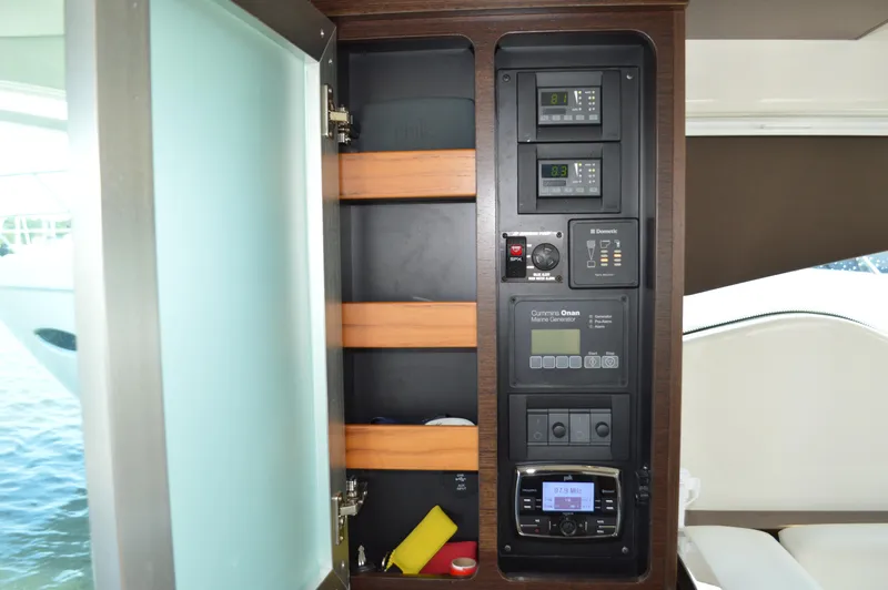 Andros Yacht Photos Pics Control panel inside 2016 Tiara Yachts C44 Coupe, featuring various electronic systems and storage shelves.