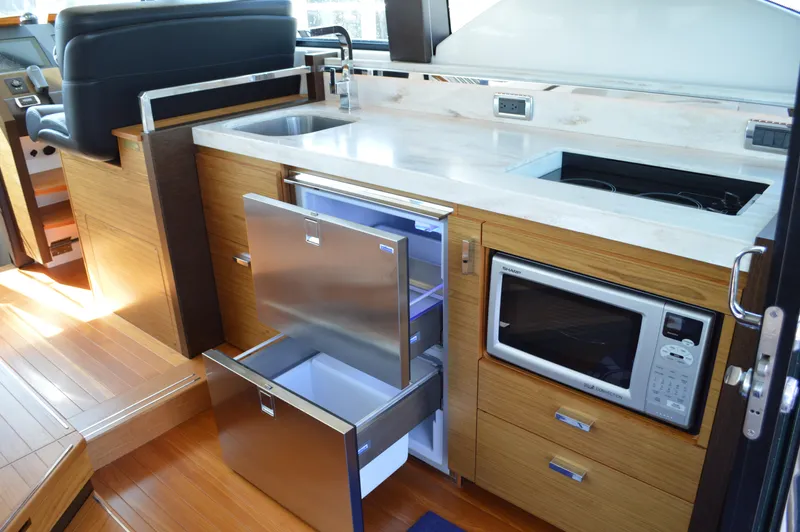 Andros Yacht Photos Pics 2016 Tiara Yachts C44 Coupe interior kitchen with sink, fridge, and microwave.