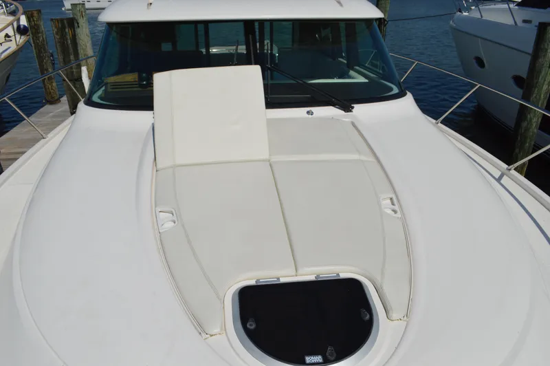 Andros Yacht Photos Pics 2016 Tiara Yachts C44 Coupe deck with sunpad and windshield, docked at marina.