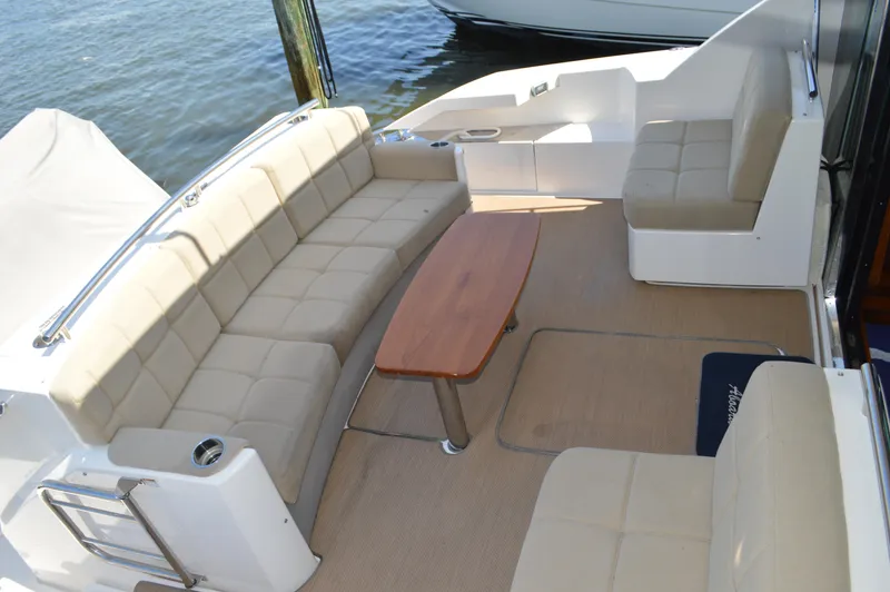 Andros Yacht Photos Pics Luxurious seating area on 2016 Tiara Yachts C44 Coupe with beige cushions and wooden table.