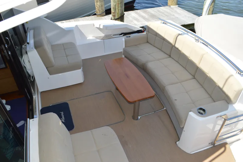 Andros Yacht Photos Pics 2016 Tiara Yachts C44 Coupe cockpit with beige seating and wooden table.