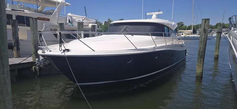 Andros Yacht Photos Pics 2016 Tiara Yachts C44 Coupe docked in a marina under clear blue skies.