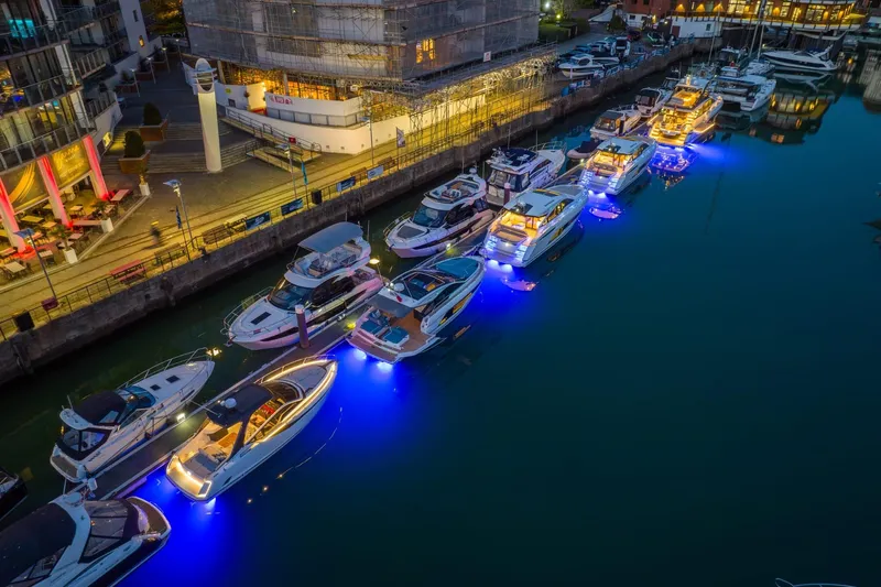 In Stock Yacht Photos Pics Marina with illuminated yachts, including 2025 Fairline Targa 45 GT, at night.