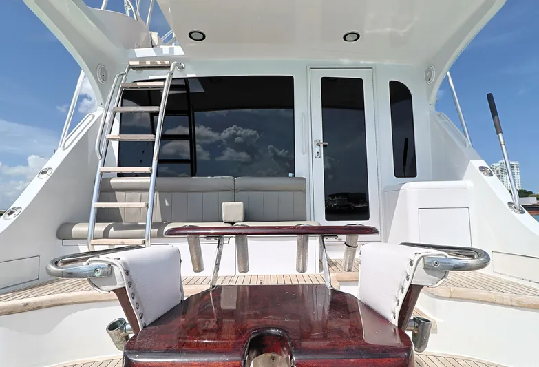  Yacht Photos Pics 2004 Hatteras 54 Convertible yacht deck with seating and ladder under clear sky.