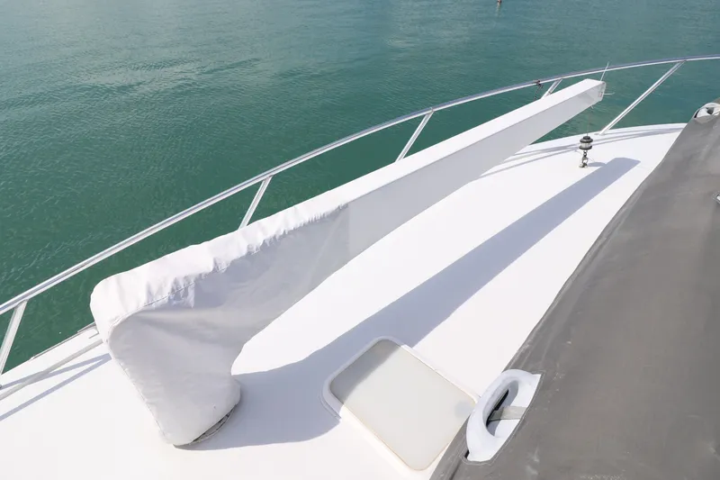  Yacht Photos Pics 2004 Hatteras 54 Convertible yacht deck with covered equipment, railing, and ocean view.