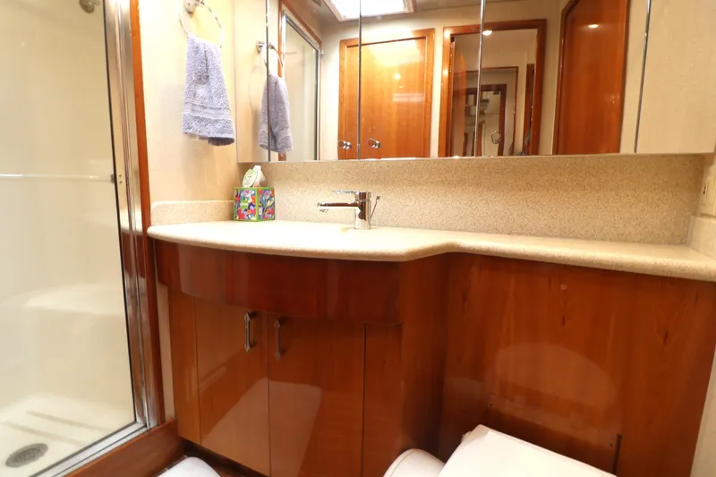  Yacht Photos Pics Luxurious bathroom in 2004 Hatteras 54 Convertible yacht with wooden cabinetry and modern fixtures.