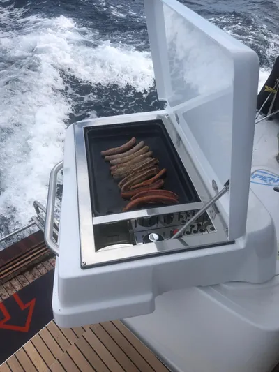  Yacht Photos Pics Outdoor grill with sausages on Lagoon 50 catamaran, 2019 model, sailing on ocean.