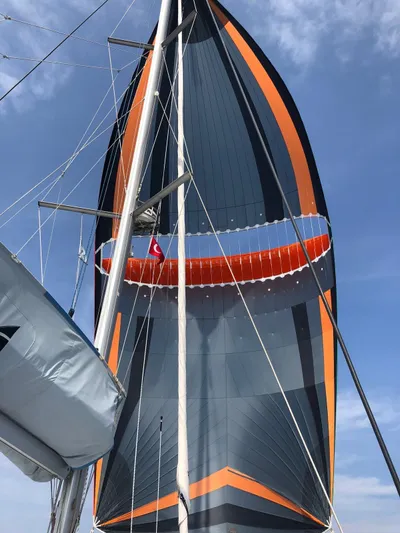  Yacht Photos Pics Sailing yacht Lagoon 50, 2019 model, with vibrant orange and black sail against blue sky.