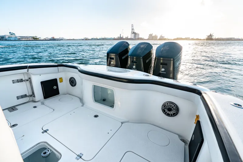  Yacht Photos Pics 2023 Yellowfin 42 Offshore boat deck with triple outboard engines on water.