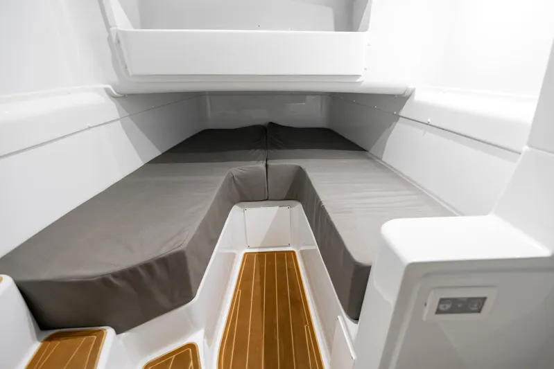  Yacht Photos Pics 2023 Yellowfin 42 Offshore cabin interior with cushioned seating and wooden flooring.