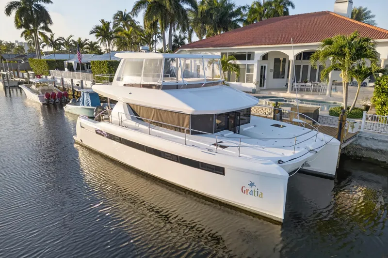  Yacht Photos Pics 2024 Leopard 46 Powercat yacht docked by a luxurious waterfront home.