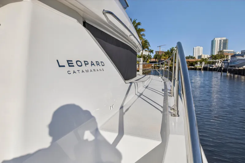  Yacht Photos Pics 2024 Leopard 46 Powercat yacht docked by waterfront, showcasing sleek design and branding.