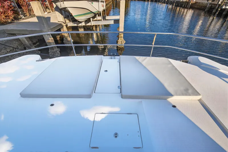  Yacht Photos Pics 2024 Leopard 46 Powercat deck with sun loungers, docked by calm waters.