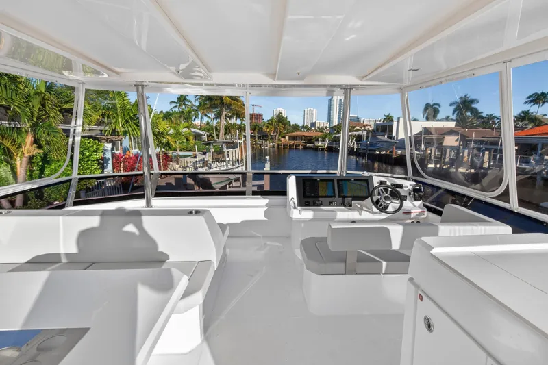  Yacht Photos Pics 2024 Leopard 46 Powercat interior with modern helm, surrounded by tropical waterfront views.