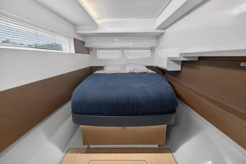  Yacht Photos Pics 2024 Leopard 46 Powercat cabin with modern design, featuring a cozy bed and sleek wood accents.