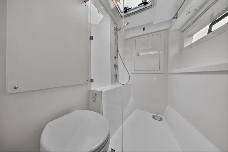  Yacht Photos Pics 2024 Leopard 46 Powercat bathroom with modern shower and toilet, featuring sleek white design.