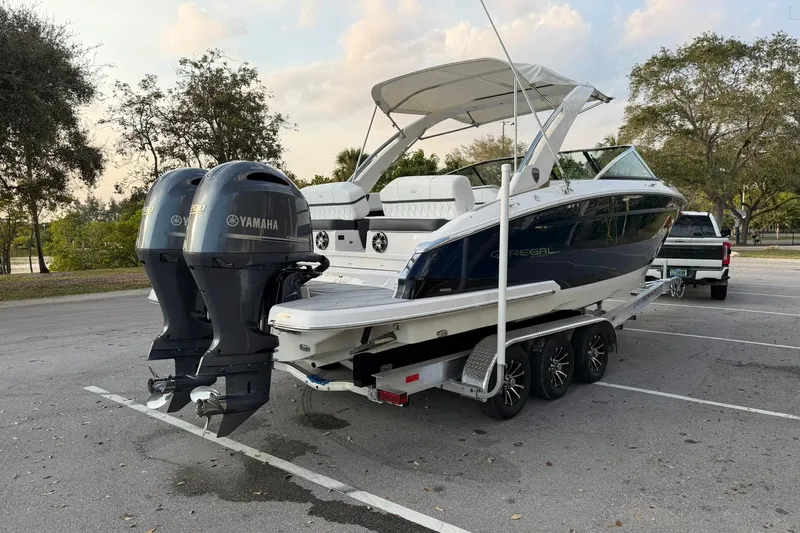  Yacht Photos Pics 2019 Regal 29 OBX boat with twin Yamaha engines on a trailer in a parking lot.