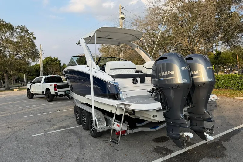 Yacht Photos Pics 2019 Regal 29 OBX boat with dual Yamaha engines on a trailer in a parking lot.