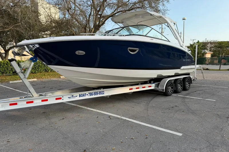  Yacht Photos Pics 2019 Regal 29 OBX boat on trailer in parking lot, side view.