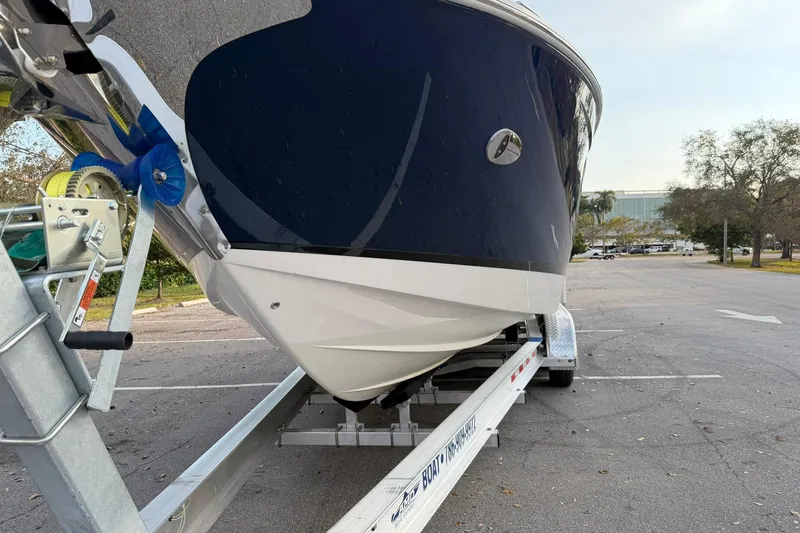  Yacht Photos Pics 2019 Regal 29 OBX boat on trailer in parking lot, front view.