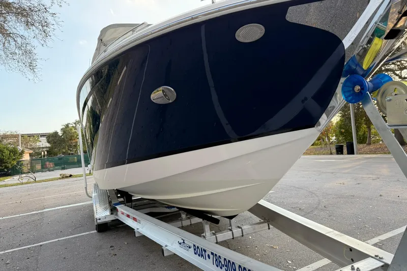  Yacht Photos Pics 2019 Regal 29 OBX boat on trailer in parking lot, side view.