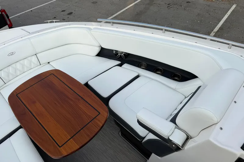  Yacht Photos Pics Luxurious seating area on a 2019 Regal 29 OBX boat with wooden table and white upholstery.