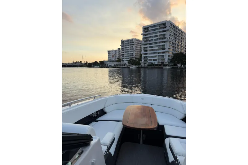  Yacht Photos Pics 2019 Regal 29 OBX boat on calm water at sunset, near modern buildings.