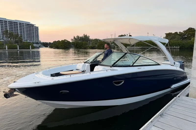  Yacht Photos Pics 2019 Regal 29 OBX boat docked at sunset, with a person onboard.