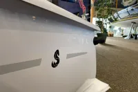 2023 Beneteau First 14 sailboat displayed indoors, showcasing sleek design and logo.