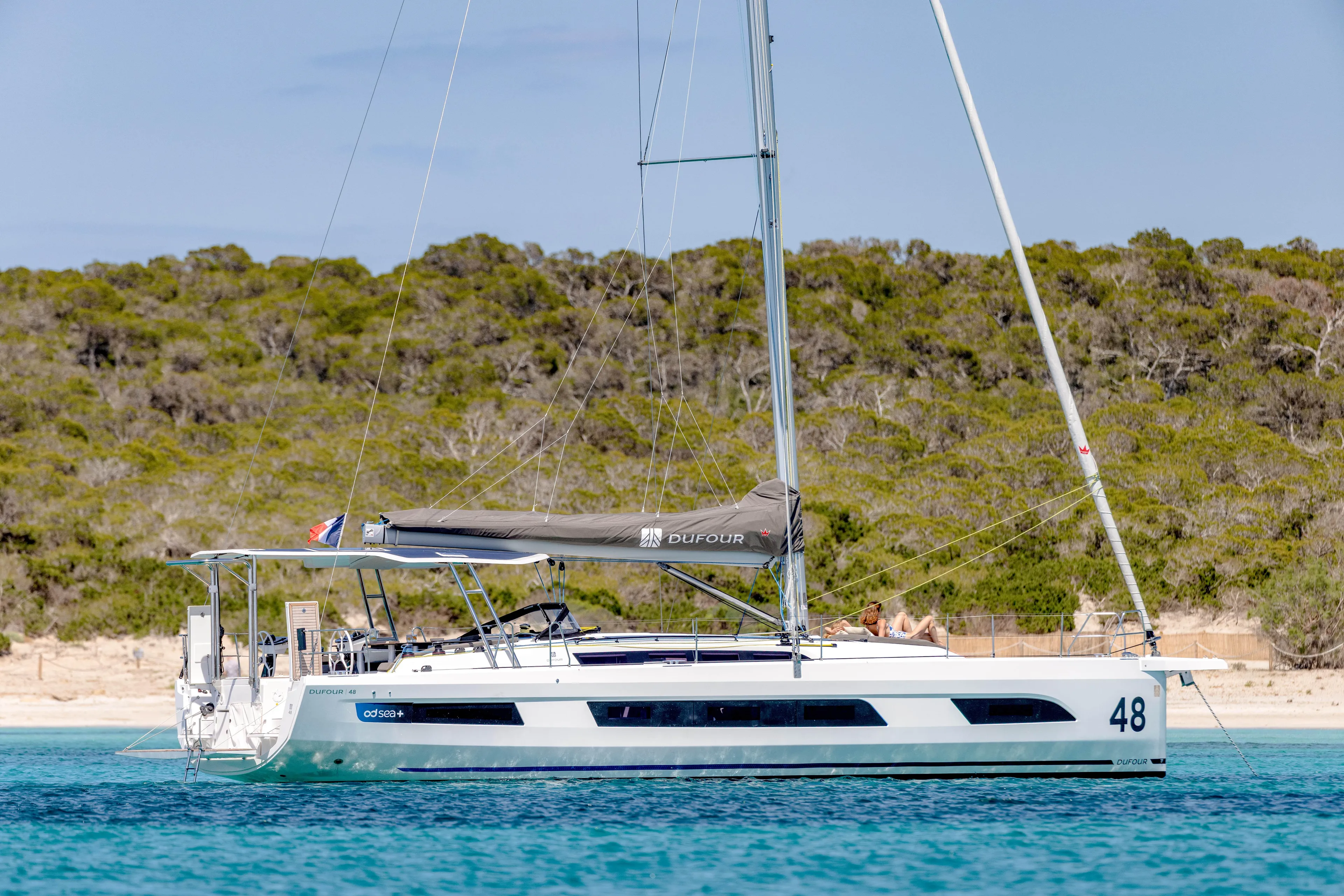  Yacht Photos Pics 2025 Dufour 48 yacht sailing near a scenic coastline.