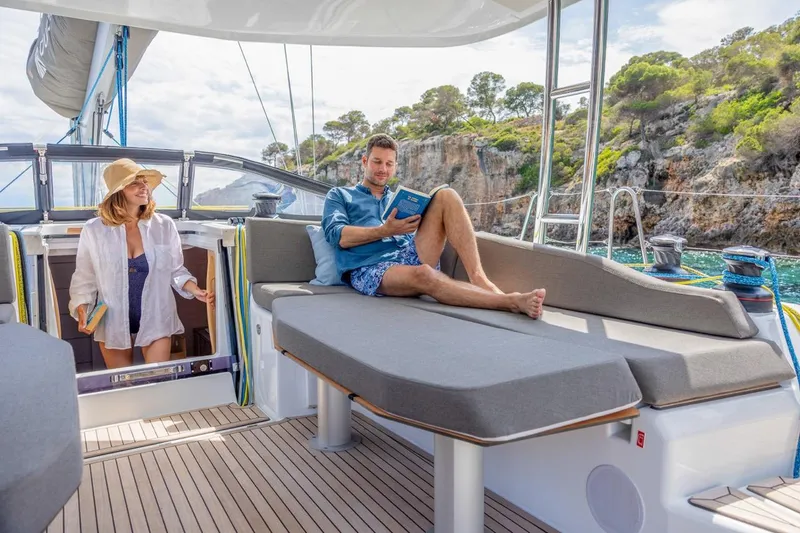  Yacht Photos Pics Couple relaxing on a 2025 Dufour 48 yacht, enjoying a scenic coastal view.