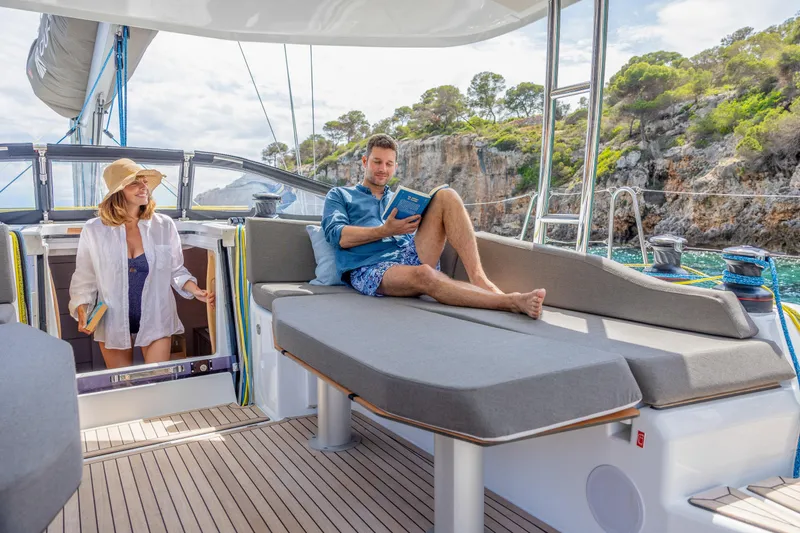  Yacht Photos Pics Couple relaxing on a 2025 Dufour 48 yacht, enjoying a scenic coastal view.