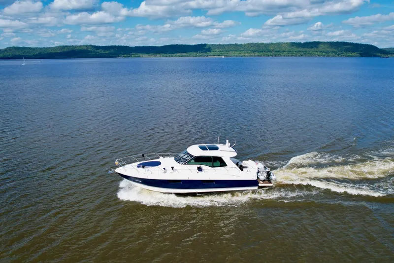 Plan B Yacht Photos Pics 2012 Cruisers Yachts 48 Cantius cruising on a serene lake under a blue sky.