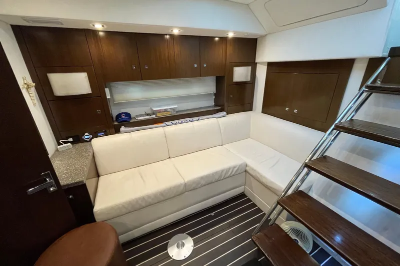 Plan B Yacht Photos Pics Luxurious interior of 2012 Cruisers Yachts 48 Cantius with white sofa and wooden cabinetry.