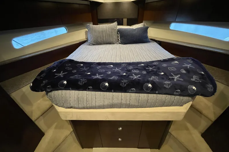 Plan B Yacht Photos Pics Luxurious bedroom interior of 2012 Cruisers Yachts 48 Cantius with nautical-themed bedding.
