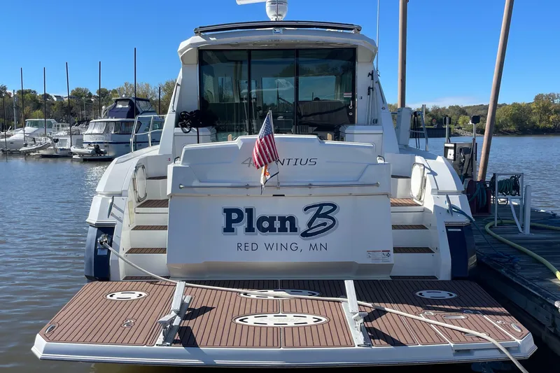 Plan B Yacht Photos Pics 2012 Cruisers Yachts 48 Cantius docked, rear view with "Plan B" name and American flag.