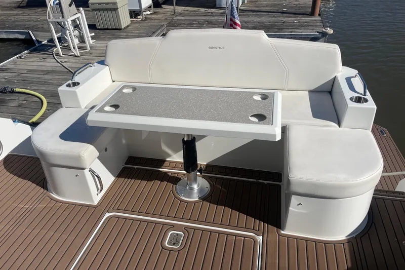 Plan B Yacht Photos Pics 2012 Cruisers Yachts 48 Cantius deck with white seating and table, docked by water.