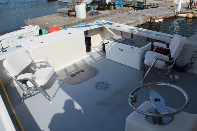 Miss Jennie Yacht Photos Pics Spacious deck of 2008 H&H Marine 38 boat with chairs and cooler.