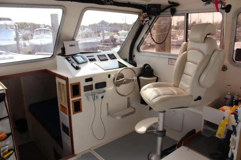 Miss Jennie Yacht Photos Pics Interior of a 2008 H&H Marine 38 boat with captain's chair and control panel.