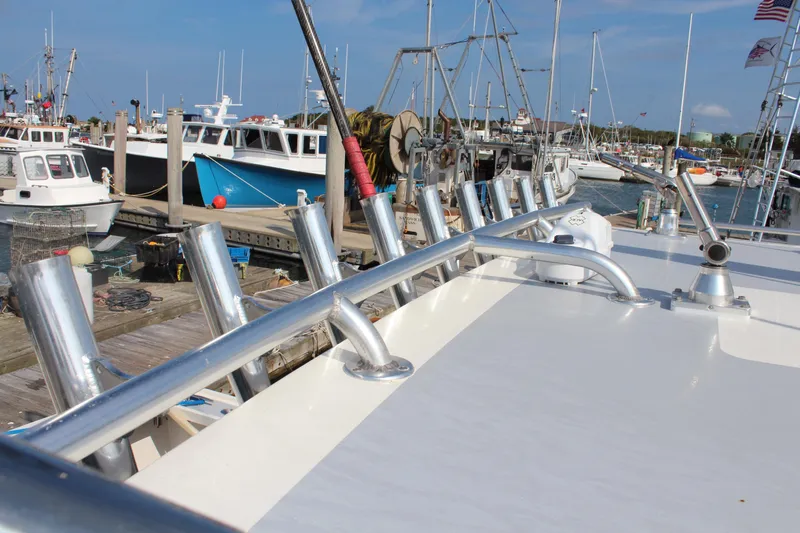 Miss Jennie Yacht Photos Pics Docked H&H Marine 38 boat, 2008 model, with fishing rod holders and other boats in the background.