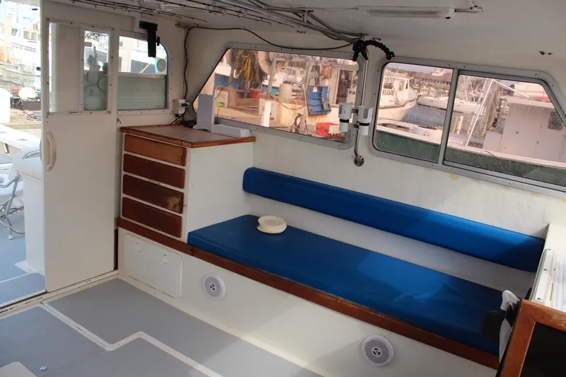 Miss Jennie Yacht Photos Pics Interior of 2008 H&H Marine 38 boat with blue seating and wooden storage.