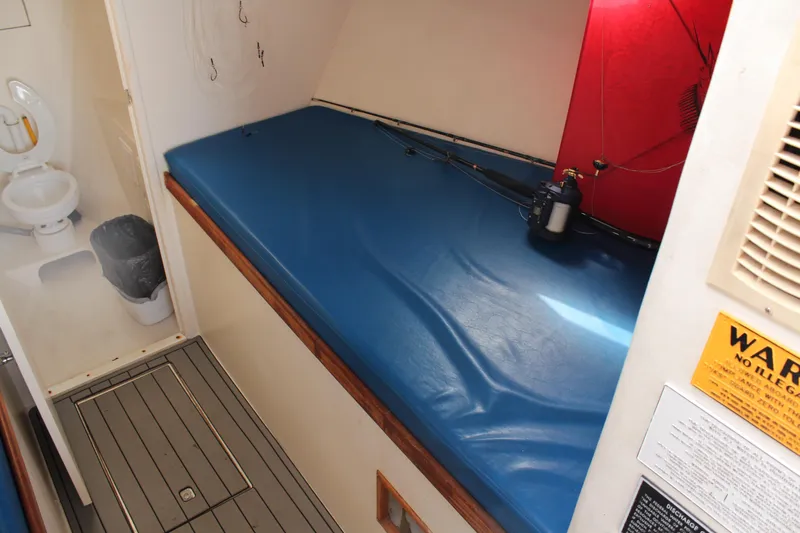 Miss Jennie Yacht Photos Pics Interior of 2008 H&H Marine 38 boat with blue cushioned seating and adjacent bathroom.