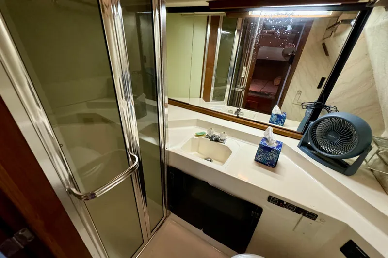 Perseverance Yacht Photos Pics 1989 Bayliner 4588 Motoryacht bathroom with shower, sink, mirror, and fan.