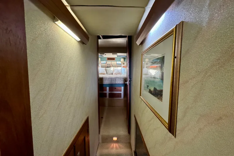Perseverance Yacht Photos Pics Hallway view inside 1989 Bayliner 4588 Motoryacht, featuring cozy bedroom and framed artwork.
