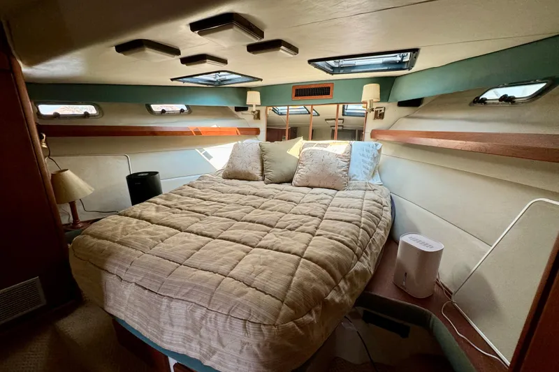 Perseverance Yacht Photos Pics Cozy bedroom interior of 1989 Bayliner 4588 Motoryacht with plush bedding and natural light.